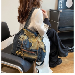 Detail of patchwork denim shoulder bag with star pattern and industrial utility pockets