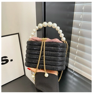 Makroansicht der schwarzen Pailletten-Abendtasche mit Perlengriff und rosa Kordelzug