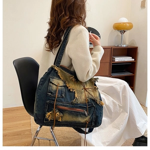 Detail of vintage denim bucket bag featuring distressed star patch and frayed edge texture
