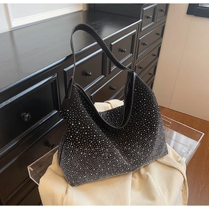 Dettaglio borsa hobo con strass scintillanti e manico in pelle nera con cuciture bianche