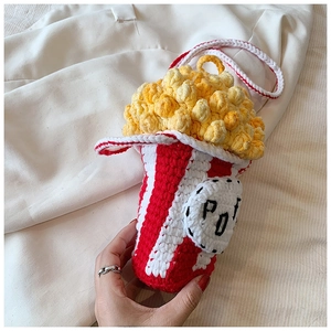 Close-up of handmade popcorn crochet bag with striped pattern and yellow textures