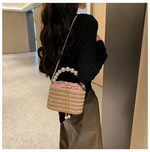 Detail der champagnergoldenen Abendtasche mit Perlen-Griff und glitzerndem Finish