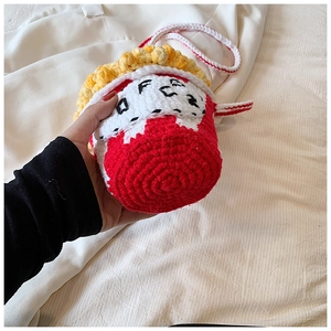 Detailed close-up of a handmade popcorn-shaped crochet bag with red and white knit texture