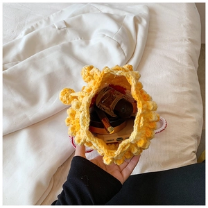Top view of yellow crochet popcorn bag interior showing phone and lipstick storage