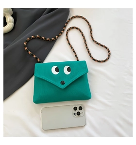 Petit sac en toile verte avec yeux de dessin animé et smartphone pour échelle