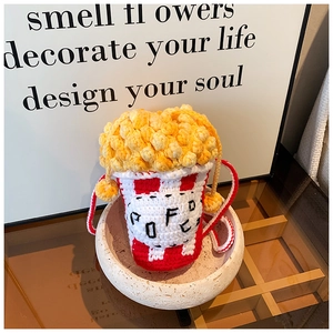 Detail of handmade crochet popcorn bag with red and white stripes and 3D textured kernels
