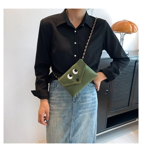 Détail du sac bandoulière en toile verte avec yeux de dessin animé sur mannequin style rétro
