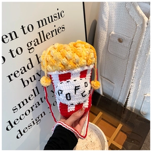 Macro shot of handmade crochet popcorn crossbody bag with red and white striped knit texture