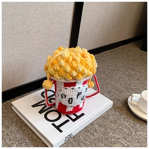 Detail of a handmade crochet popcorn bag with red and white stripes on a book