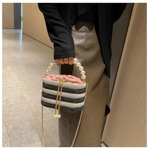 Detail der glitzernden Abendtasche mit Perlen Griff und goldener Metallkette Riemen