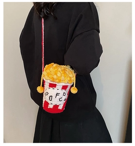 Detail showing hand-knitted popcorn bucket crossbody bag with red and white stripes