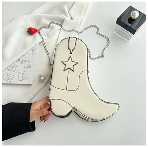Detail of creative boot-shaped crossbody bag with star patch and metal chain strap