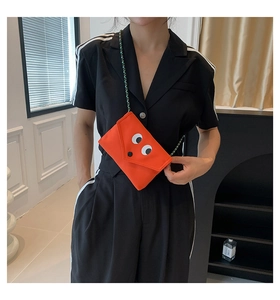 Détail du mini sac orange en toile avec yeux de monstre et bandoulière tressée