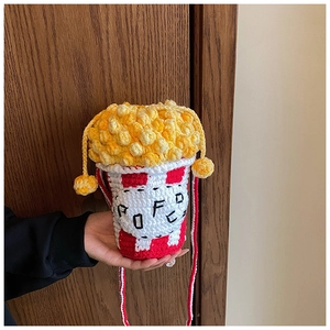 Detailed close-up of handmade popcorn-shaped crochet crossbody bag with red and white stripes
