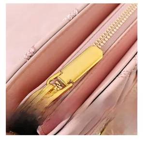 Détail de la fermeture éclair dorée et du cuir rose matelassé sur un sac bandoulière