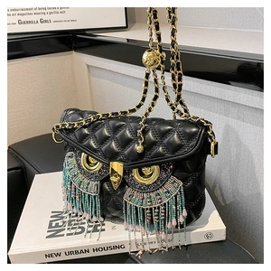 Détail du sac hibou en cuir matelassé noir avec pompons en perles et bandoulière chaîne