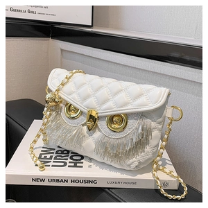 Détail du sac à bandoulière matelassé blanc avec pompons hibou et fermoirs dorés