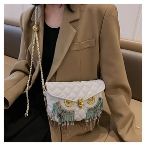 Vue détaillée du sac matelassé blanc avec yeux de chouette et franges colorées