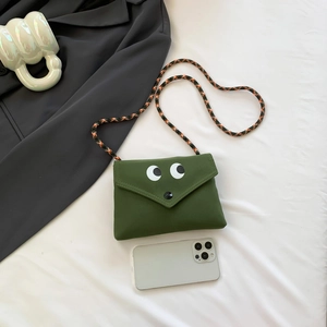 Petit sac bandoulière vert en toile avec de grands yeux et une sangle tressée colorée