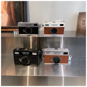 Detailed view of four retro camera-style crossbody bags in various colorways on display