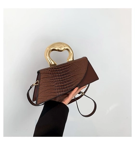 Detailed shot of dark brown stone pattern bag with artistic gold metal handle