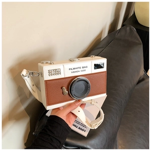 Detailed view of creative camera-shaped crossbody bag with faux leather texture