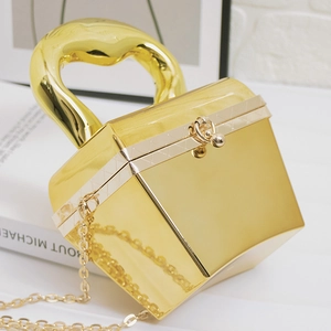 Detail der goldenen Acryl-Box-Tasche mit Spiegeleffekt und dickem Metallgriff