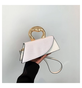 Detailed shot of white crocodile pattern handbag with unique golden lava metal handle