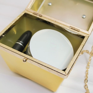 Detail einer Acryl-Clutch mit Goldrahmen, Kettenriemen und luxuriösem Kugelverschluss