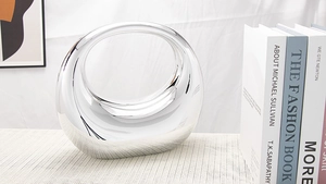 Gros plan d'un vase en céramique argentée avec une finition miroir métallique moderne