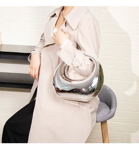 Gros plan du sac à main en acrylique argenté brillant avec finition miroir et design incurvé
