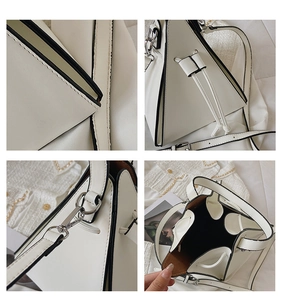 Detail view of a white triangle handbag showing silver hardware and matte leather texture