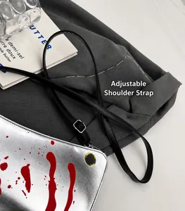 Detail of adjustable black shoulder strap with metal buckle on silver crossbody bag