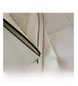 Detail showing high-density stitching and black edge painting on white leather bag