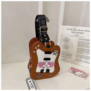 Détail du sac bandoulière en forme de guitare avec rivets et large bandoulière imprimée