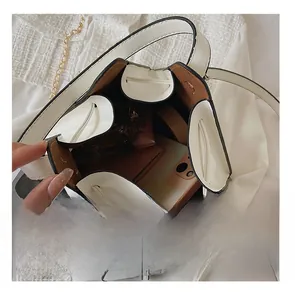 Internal view of a white triangular bag showing brown lining and spacious storage capacity