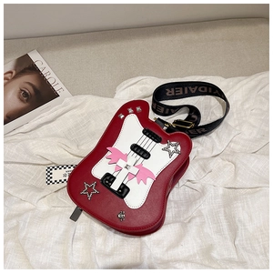Détail d'un sac bandoulière rouge en forme de violon avec paillettes d'étoiles et sangle