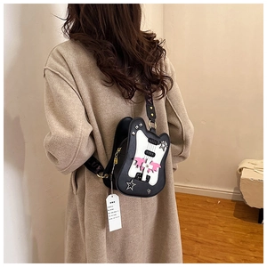 Detail of violin-shaped crossbody bag featuring metal studs and wide logo shoulder strap