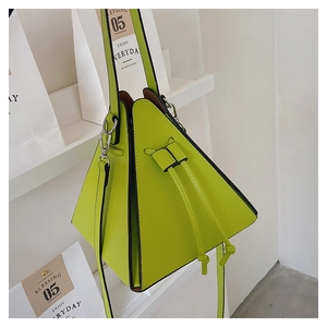 Detail of lime green triangular handbag featuring silver metal hardware and crossbody strap