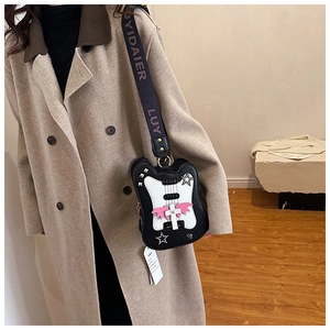 Detail view of guitar-shaped crossbody bag with bat wings and rhinestone star accents