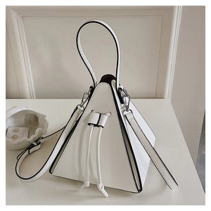 Detail of the white pyramid bag with black lacquered edges and stylish drawstring closure