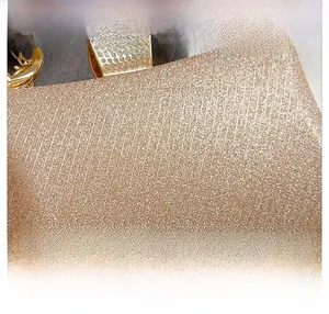 Detail showing glitter vertical texture on gold evening clutch with diamond clasp
