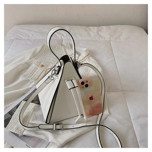 Detail view of a white geometric triangle handbag with contrast black piping and drawstrings