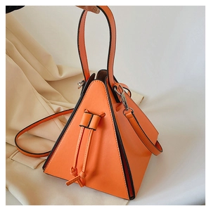 Detailed close-up of a bright orange geometric triangle handbag with black edge accents