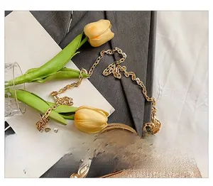 Detailed macro view of the sparkling gold evening bag with rhinestone clasp and metal chain