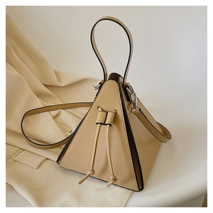 Detail of light beige triangular pyramid bag with curved handle and thin shoulder strap