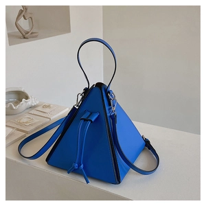 Detail of blue pyramid PU leather handbag featuring a drawstring closure and silver hardware