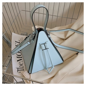 Detail of light blue triangular handbag with drawstring in a metal shopping cart
