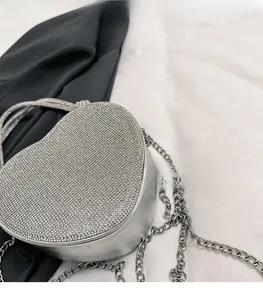 Vue de dessus d'un sac à main argenté en forme de cœur avec strass et chaîne en métal
