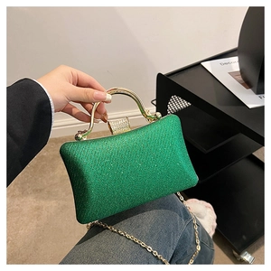 Detailed macro of a green sequined evening clutch bag with golden handle and rhinestones